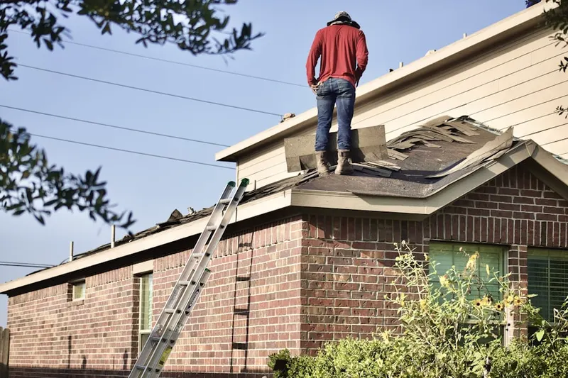 Professional roofer working on a residential roof in Hardin